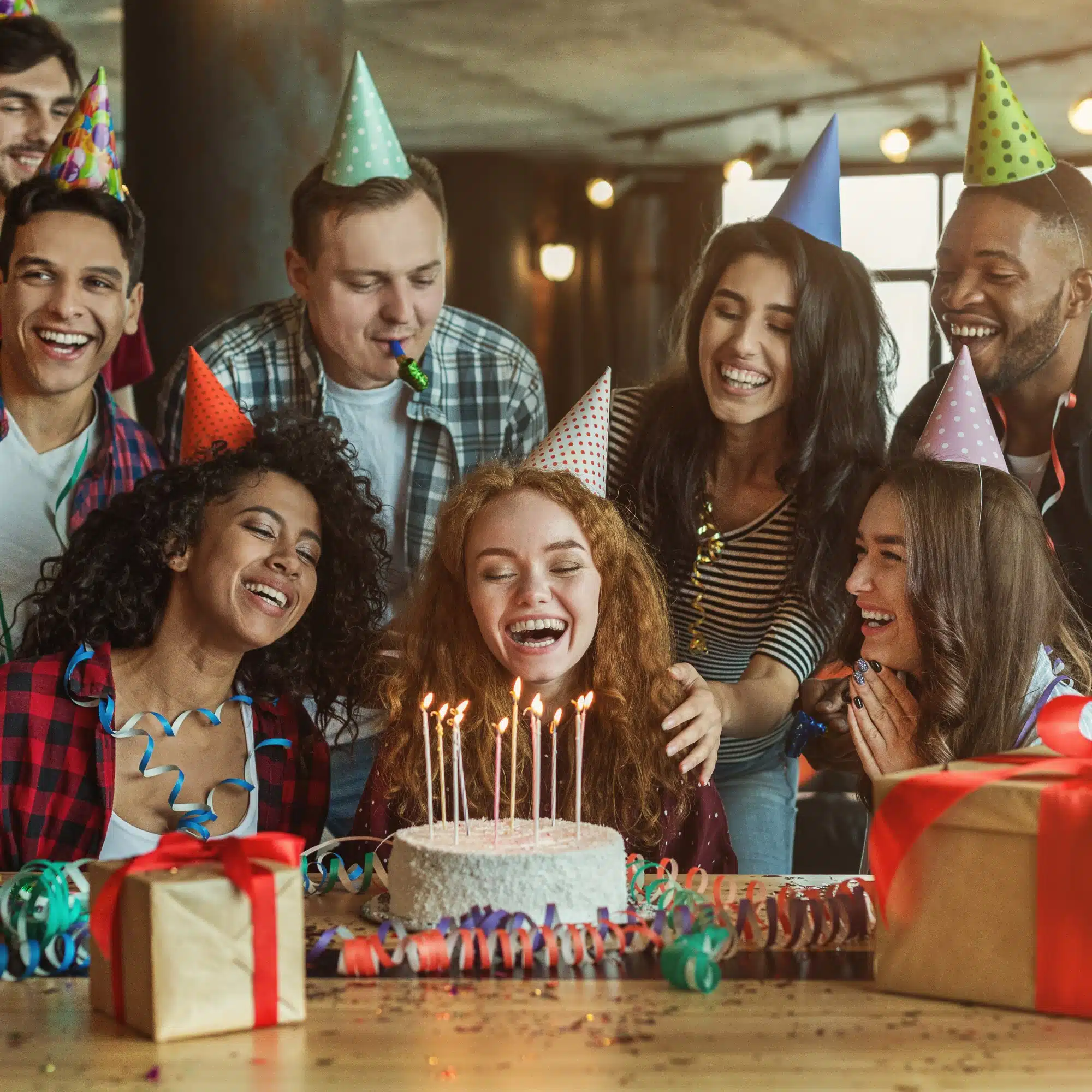 Friends celebrating around a birthday cake with candles