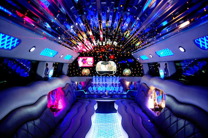 Limousine interior with a colorful starlight ceiling and bar