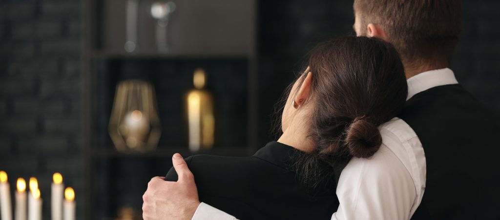 A couple comforting each other during a memorial service